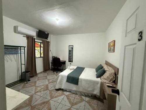 a bedroom with a bed and a desk and a window at Tunco SurfHouse in El Sunzal
