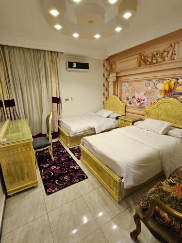 a hotel room with two beds and a television at Villas with direct sea views and apartments with partial sea views in Miami, Alexandria, Al Safwa Tower, in Alexandria