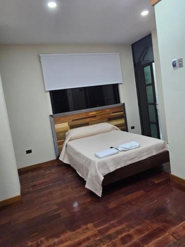 a bedroom with a bed and a large window at RoofTop8 in Cochabamba