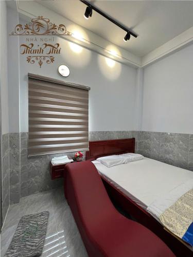 a bedroom with a large bed and a sign on the wall at Nhà nghỉ Thanh Thư 2 in Vị Thanh