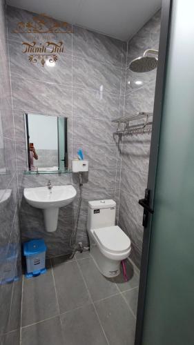 a bathroom with a toilet and a sink and a mirror at Nhà nghỉ Thanh Thư 2 in Vị Thanh