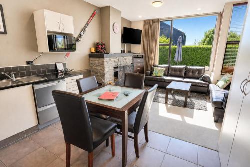 a kitchen and living room with a table and chairs at Cardrona Sanctuary by Aotearoa Escapes in Cardrona