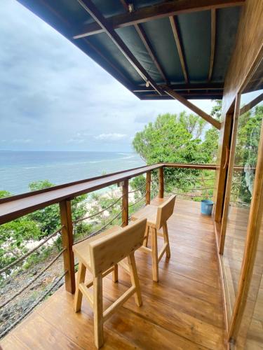 a room with a balcony with a view of the ocean at Bara Village Guest House Bira in Bira
