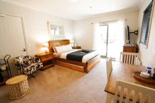 a bedroom with a bed and a chair and a table at Cardrona Ridge by Aotearoa Escapees in Cardrona