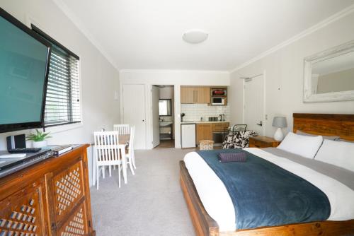 a bedroom with a large bed and a television at Cardrona Ridge by Aotearoa Escapees in Cardrona