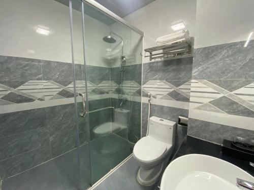 a bathroom with a shower and a toilet and a sink at Khách sạn Nậm Rốm in Diện Biên Phủ