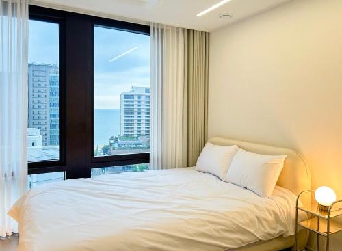 a bedroom with a bed and a large window at Stay in WAVE in Ch'ŏngsap'o