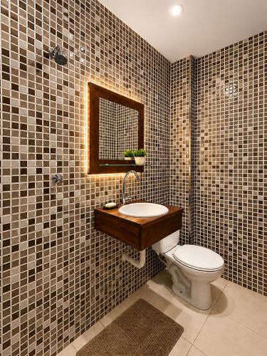 a bathroom with a toilet and a sink and a mirror at Studio no Centro com Wi-Fi in Manaus