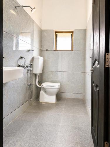 a bathroom with a toilet and a sink at hotel raj palace in Londa