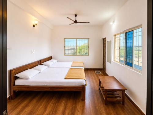 a bedroom with a bed and a table and windows at hotel raj palace in Londa