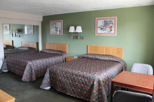 A bed or beds in a room at American Motor Inn - Rock Island