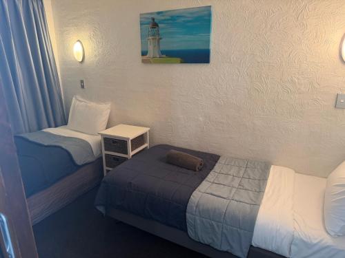 a room with two beds and a lighthouse on the wall at AAA Mana Motel in Porirua