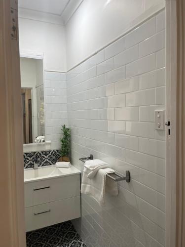 a white bathroom with a sink and a mirror at The Cooby in Spearwood