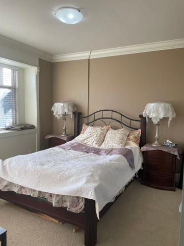 a bedroom with a bed with two nightstands and two lamps at 温哥华列治文别墅民宿60 in Richmond