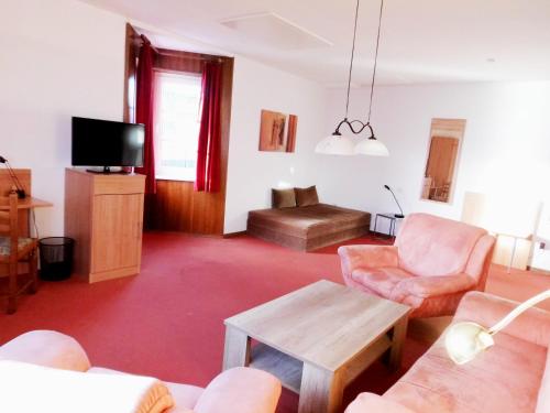 a living room with a couch and a table at Hotel Seerose in Wilhelmshaven