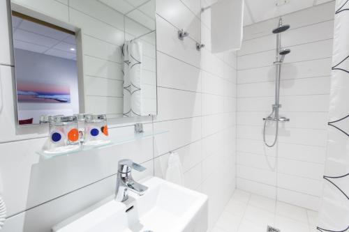 
a bathroom with a sink, mirror and bathtub at Centrum Hotel in Akureyri
