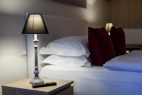 a lamp on a table next to a bed with pillows at Centrum Hotel in Akureyri