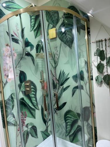 a shower stall with a green floral wallpaper at Loft Studio in Davenham