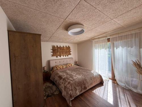 a bedroom with a bed and a large window at Mango namelis in Žuvininkai