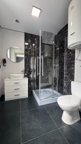 a bathroom with a shower and a toilet and a sink at Готель Колиба Колорит in Tatariv