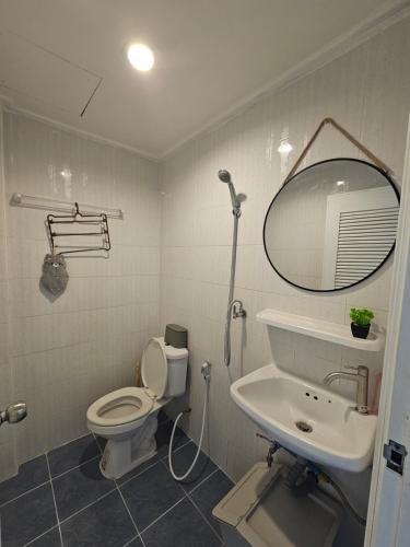 a bathroom with a toilet and a sink and a mirror at Papa house in Pak Kret