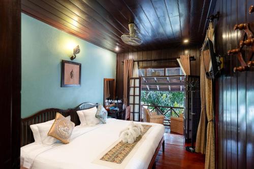 a bedroom with a bed with a cat laying on it at Ban Lakkham River View in Luang Prabang