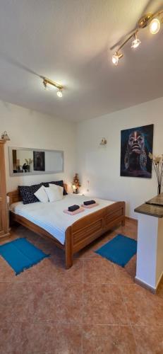 a bedroom with a large bed with blue rugs at Studio Apartman DORA in Senj