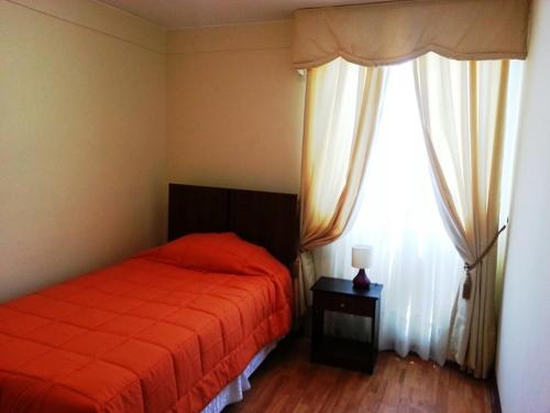 um quarto com uma cama e uma grande janela em Hospedaje Rancagua - Centro - Hermoso Departamento em Rancagua