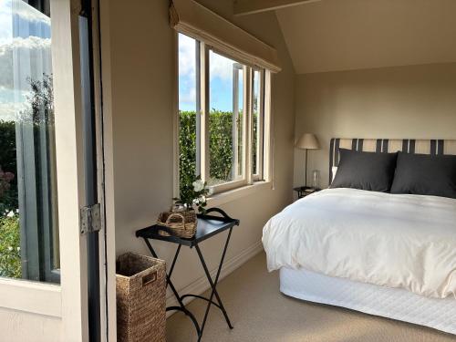a bedroom with a bed and a table next to a window at Tswalu in Raglan