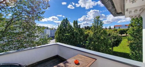 Eine Bank auf einem Balkon mit Blick auf einen Hof in der Unterkunft Fürstlich Wohnen am Circus über den Dächern von Putbus in Putbus
