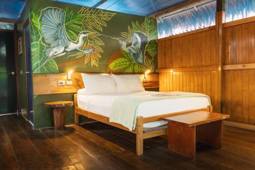 a bedroom with a bed with a painting on the wall at Amazon Muyuna Lodge - All Inclusive in Paraíso