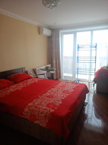 a bedroom with a red bed with a red blanket at Сергей Сергеевич in Akhaltsikhe