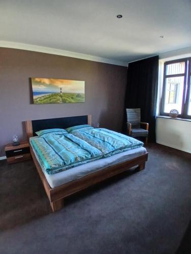 a bedroom with a bed with a painting on the wall at Sonnige Ferienwohnung Am Sternberg in Extertal