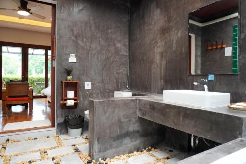ein Badezimmer mit Waschbecken und Spiegel in der Unterkunft Cascade Tara in Na Mueang
