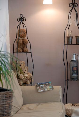 a living room with a couch and two shelves with teddy bears at La Maison Vieille Maison d'Hôtes & Gîtes in Carcassonne