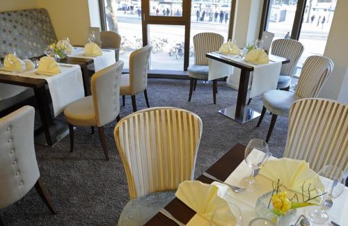 a dining room with tables and chairs in a restaurant at Central-Hotel Kaiserhof in Hannover