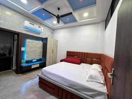 a bedroom with a bed and a blue ceiling at Mitanvi the heaven in Ujjain