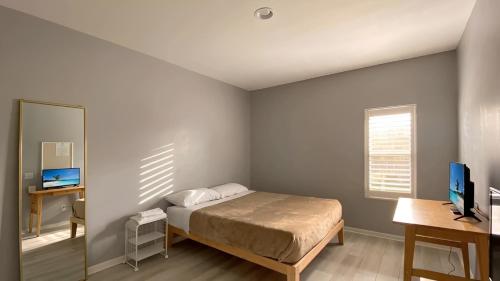 a bedroom with a bed and a desk and a mirror at Corporate Retreat - Stylish 2BR Condo with Pool, Balcony & Fast Wi-Fi, Minutes from Downtown Wilmington in Wilmington