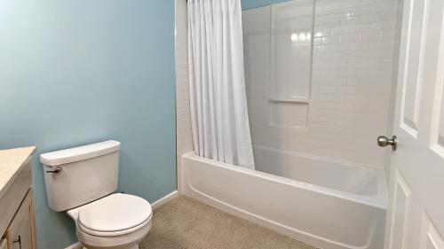 a bathroom with a white toilet and a shower at Corporate Retreat - Stylish 2BR Condo with Pool, Balcony & Fast Wi-Fi, Minutes from Downtown Wilmington in Wilmington
