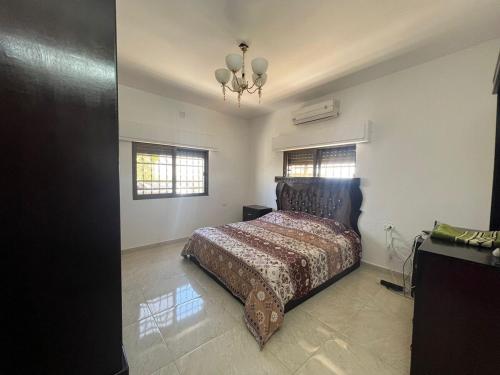 a bedroom with a bed and a chandelier at Al Maha Farm in Jerash