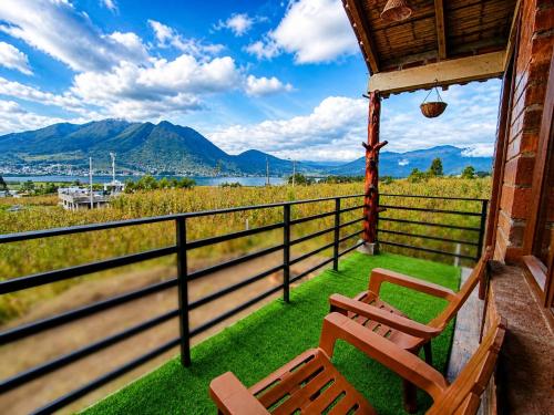 two benches sitting on a porch with a view of the mountains at Minkay-Lodge in Otavalo
