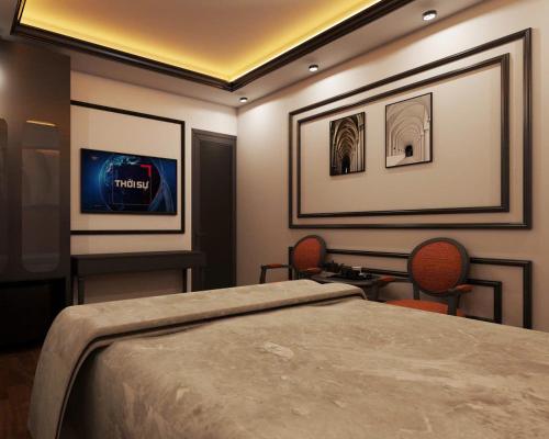 a bedroom with a bed and two chairs and a tv at Villa Victoria Me Tri in Hanoi