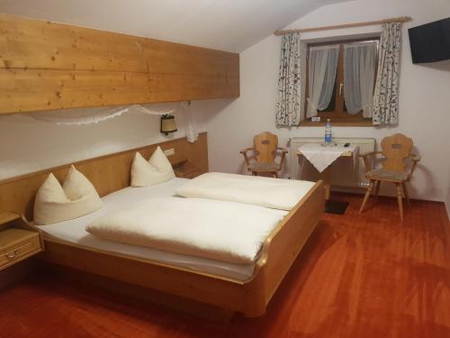 Schlafzimmer mit einem Bett, einem Tisch und Stühlen in der Unterkunft Zum Schweizerbartl in Garmisch-Partenkirchen