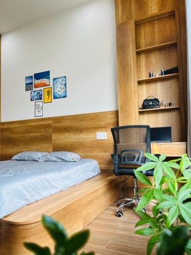 a bedroom with a bed and a desk and a chair at Ruby Home Quy Nhon in Quy Nhon