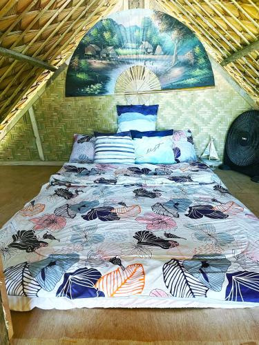 a bed with a colorful comforter in a room at Ālon in Linukso