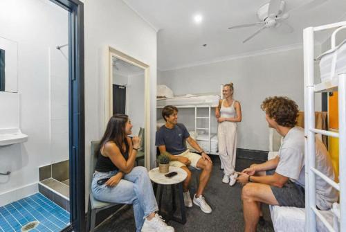 a group of people sitting in a dorm room at London Gate Backpackers Hostel in Sydney