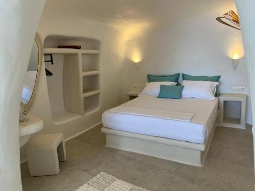 a small white bedroom with a bed and a mirror at Naya seaside apartment in Firopótamos