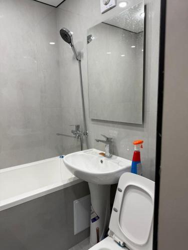 a bathroom with a sink and a toilet and a mirror at Квартира на Толе би in Taraz