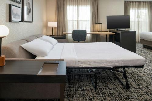 a hotel room with a large bed and a couch at Residence Inn Columbia in Columbia