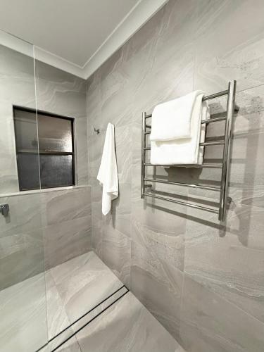 a bathroom with a towel rack and a shower at Ferguson House in Cessnock